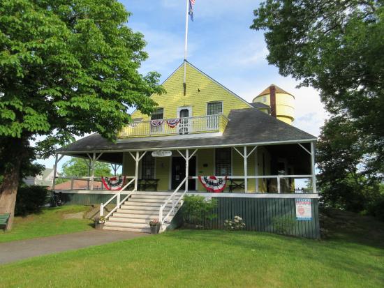 The yellow 5th Maine Regiment Museum with its wraparound porch and bunting on Peaks Island