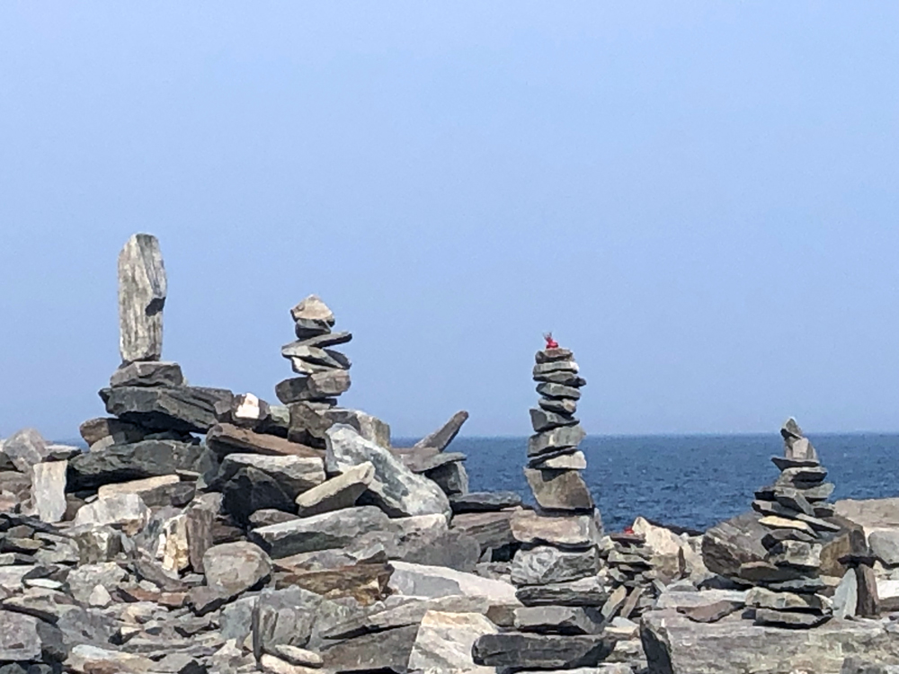 Stacked stone cairns along the back shore of Peaks Island with the open ocean behind